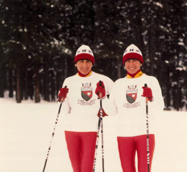 Sharon Anne & Shirley Anne Firth stand in ski gear on a snowy hill
